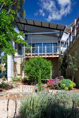 The old and new sections feature expansive outdoor terraces. Upstairs, the deck off the living room and master bedroom overlooks the garden below and boasts city views in the distance.